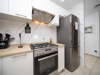 a kitchen with a stove and a refrigerator at Elegant and Spacious 2-Bedroom Apartment in JVT in Dubai