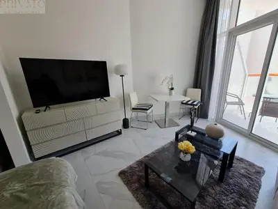 a living room with a large flat screen tv at Cosy studio l close to Downtown in Dubai