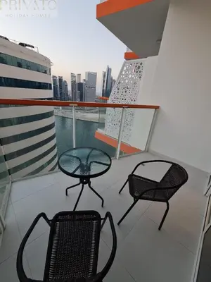 two chairs and a table on top of a balcony at Cosy studio l close to Downtown in Dubai