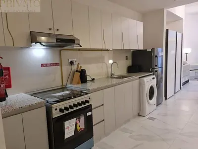 a kitchen with a stove and a washing machine at Cosy studio l close to Downtown in Dubai