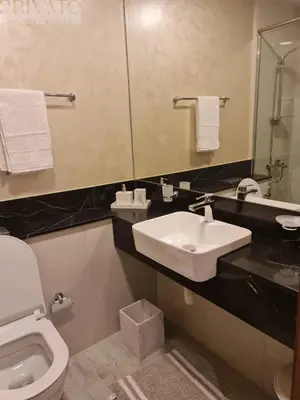 a bathroom with a sink and a toilet and a mirror at Cosy studio l close to Downtown in Dubai