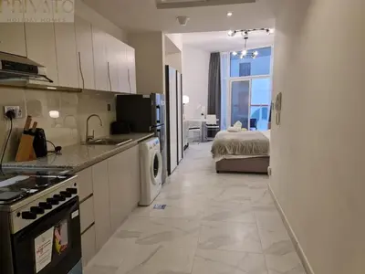 a kitchen with a sink and a bed in a room at Cosy studio l close to Downtown in Dubai
