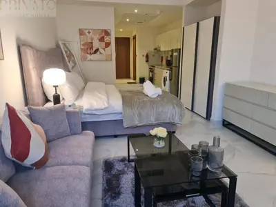 a living room with a bed and a couch and a table at Cosy studio l close to Downtown in Dubai