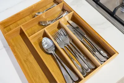 a wooden tray with silver utensils on a counter at Luxury 2BR in Meydan Near Downtown & Dubai Mall in Dubai