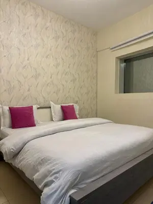 a large bed with purple and white pillows on it at Apartment in dubai in Dubai