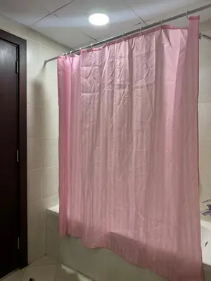 a pink shower curtain in a bathroom with a tub at Apartment in dubai in Dubai