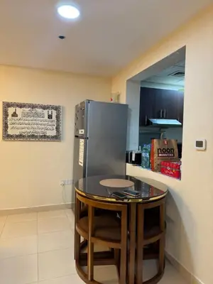 a kitchen with a small table and a refrigerator at Apartment in dubai in Dubai