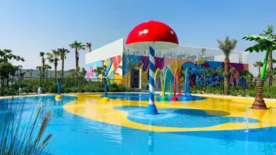 a large pool at a theme park with a building at Amazing 3BHK Townhouse in Damac Hills 2 upto 10PLL in Dubai