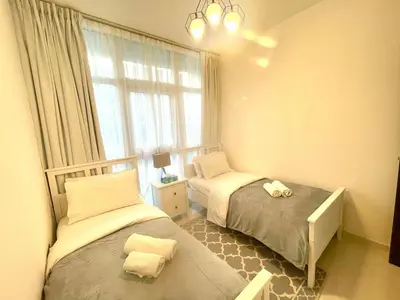 a small bedroom with two beds and a window at Amazing 3BHK Townhouse in Damac Hills 2 upto 10PLL in Dubai