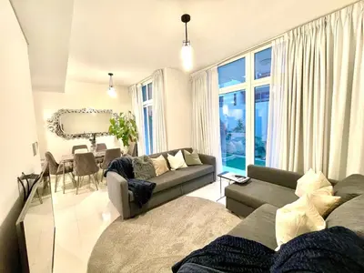 a living room with a couch and a table at Amazing 3BHK Townhouse in Damac Hills 2 upto 10PLL in Dubai