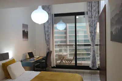 a bedroom with a bed and a desk and a window at Cosy 1 bed in Dubai Marina in Dubai