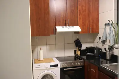 a small kitchen with a washer and a sink at Cosy 1 bed in Dubai Marina in Dubai