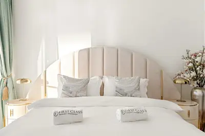 a white bed with two pillows on top of it at Elegant 1BR Apt with Balcony Views of Burj Khalifa & Dubai Canal in Dubai