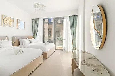 a hotel room with two beds and a mirror at Elegant 1BR Apt with Balcony Views of Burj Khalifa & Dubai Canal in Dubai