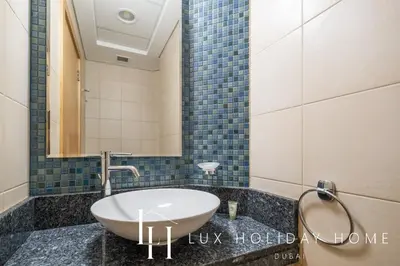 a bathroom with a sink and a mirror at LUX The Shoreline Palm Island Skyline Suite 2 in Dubai