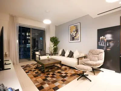 a living room with a couch and two chairs at Luxury 2BR in Sobha Hartland in Dubai