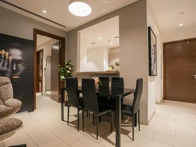 a dining room with a black table and black chairs at Luxury 2BR in Sobha Hartland in Dubai