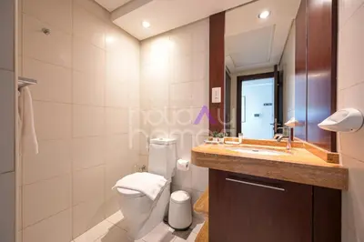 a bathroom with a toilet and a sink and a mirror at Modern 1BR in Burj Views Tower Downtown in Dubai