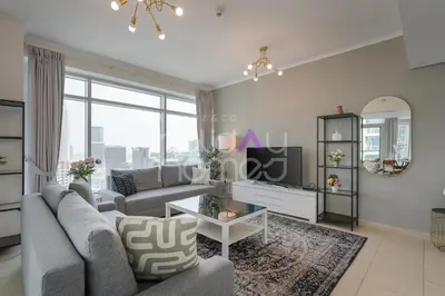 a living room with a couch and a tv at Modern 1BR in Burj Views Tower Downtown in Dubai