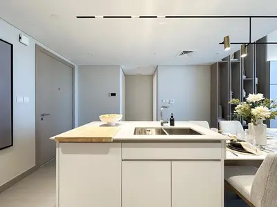 a kitchen with a sink and a table with chairs at Trophy-Aesthetic Apartment w Skyline and Dubai in Dubai