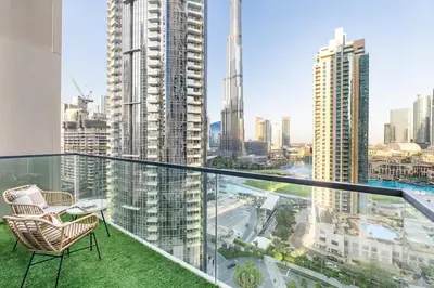 a balcony with a chair and a view of a city at Luxury 4BR with Hermes Touch & Burj Khalifa View in Dubai