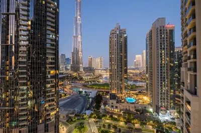 a city skyline at night with tall buildings at Luxury 4BR with Hermes Touch & Burj Khalifa View in Dubai
