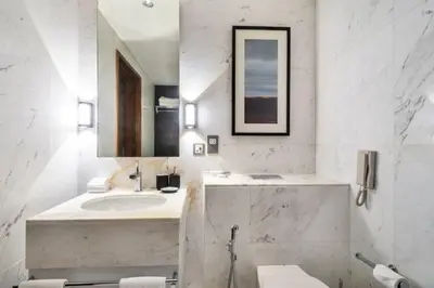 a white bathroom with a sink and a mirror at Luxury Studio in Emaar Residence Fashion Avenue in Dubai