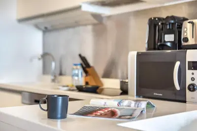 a kitchen counter with a coffee mug and a microwave at Luxury Studio in Emaar Residence Fashion Avenue in Dubai