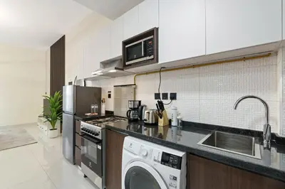 a kitchen with a washer and a sink and a dishwasher at Modern Studio with all Amenities Ideal Location in Dubai