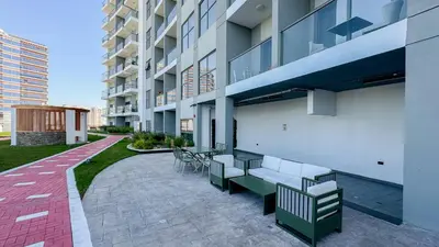 a patio with benches and tables outside of a building at Modern Studio with all Amenities Ideal Location in Dubai