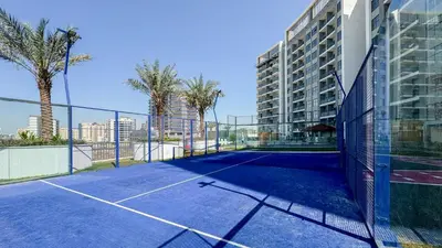 a tennis court in front of a building at Modern Studio with all Amenities Ideal Location in Dubai