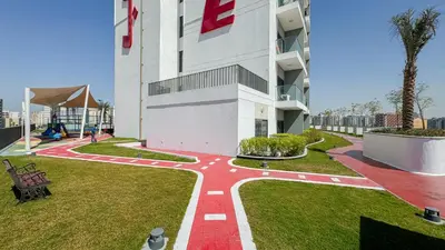 a building with a red pathway in front of it at Modern Studio with all Amenities Ideal Location in Dubai