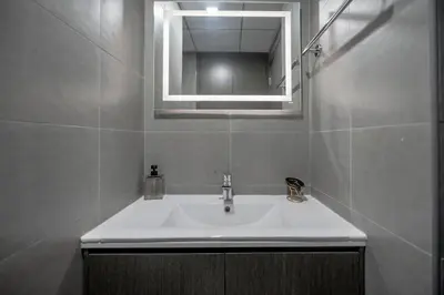 a bathroom with a white sink and a mirror at Clever Guest 029 Bella Rose in Dubai