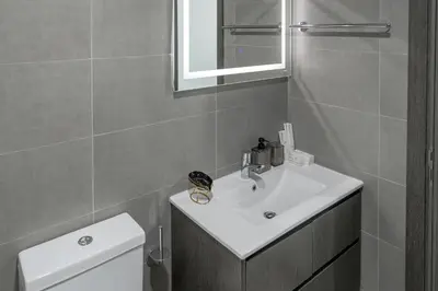 a bathroom with a sink and a toilet and a mirror at Clever Guest 029 Bella Rose in Dubai