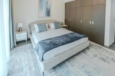 a bedroom with a large bed and a wooden cabinet at Clever Guest 029 Bella Rose in Dubai