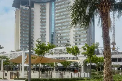a white building with a surfboard and a palm tree at Clever Guest 029 Bella Rose in Dubai