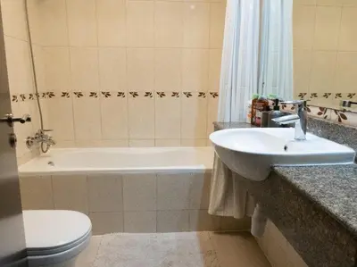 a bathroom with a sink and a tub and a toilet at Bright studio with new furniture in Dubai