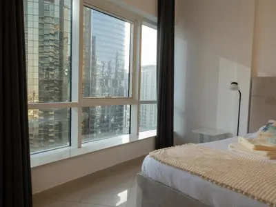 a bedroom with a large window with a view of a city at Bright studio with new furniture in Dubai