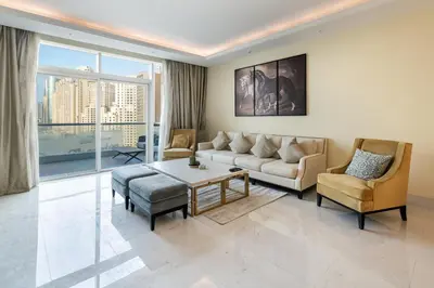 a living room with a couch and a table and chairs at Luxury 4BR Apartment in JBR Private Beach Access in Dubai