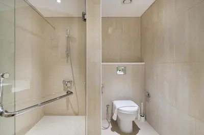 a bathroom with a toilet and a glass shower at Luxury 4BR Apartment in JBR Private Beach Access in Dubai