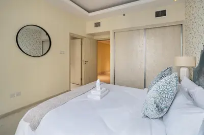 a bedroom with a white bed and a mirror at Luxury 4BR Apartment in JBR Private Beach Access in Dubai