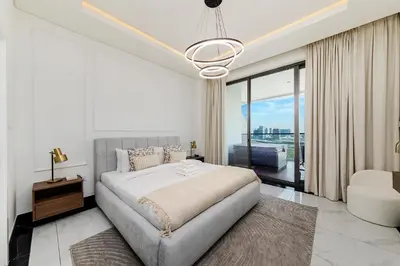 a white bedroom with a large bed and a window at Luxury Apartment in Business Bay in Dubai