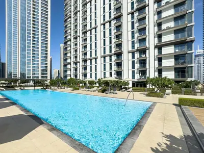 a large swimming pool in front of tall buildings at Modern 1BR in DOWNTOWN I Near DUBAI MALL & FOUNTAIN in Dubai