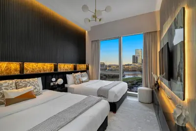 a hotel room with two beds and a large window at Gogoto2 Lux Burj Khalifa View 5 min Dubai Mall PS5 NYE Fireworks View in Dubai