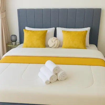 a bed with two rolled towels on it at Azizi Rivieira Meydan, Dubai Luxury Studio with Burjkhalifa and Pool views in Dubai