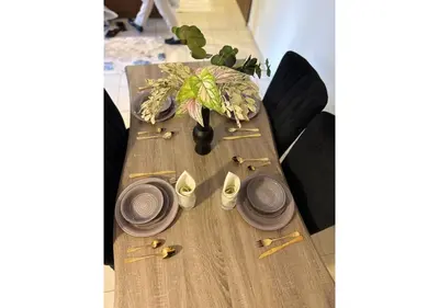 a wooden table with plates and a vase on it at Centrally Located in Business Bay - Huge 1 Bedroom Hall in Executive Towers in Dubai
