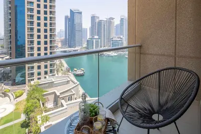 a balcony with a chair and a view of the water at Frank Porter - Beauport Tower in Dubai
