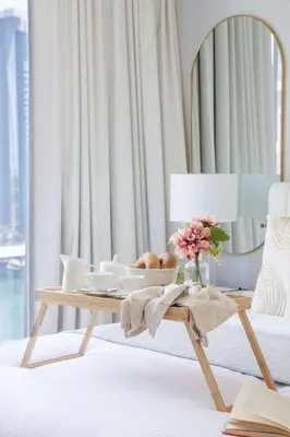 a table with a bowl of bread and a vase of flowers at Frank Porter - Beauport Tower in Dubai