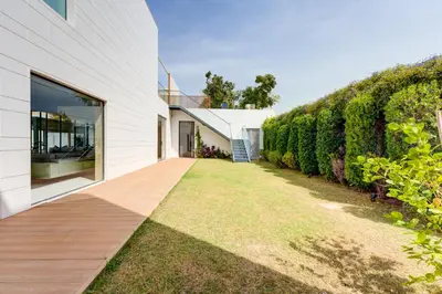 a garden path leading to a white house with a hedge at Resort Villa 19 in Dubai