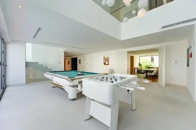 a large white room with a pool table and a bill at Resort Villa 19 in Dubai
